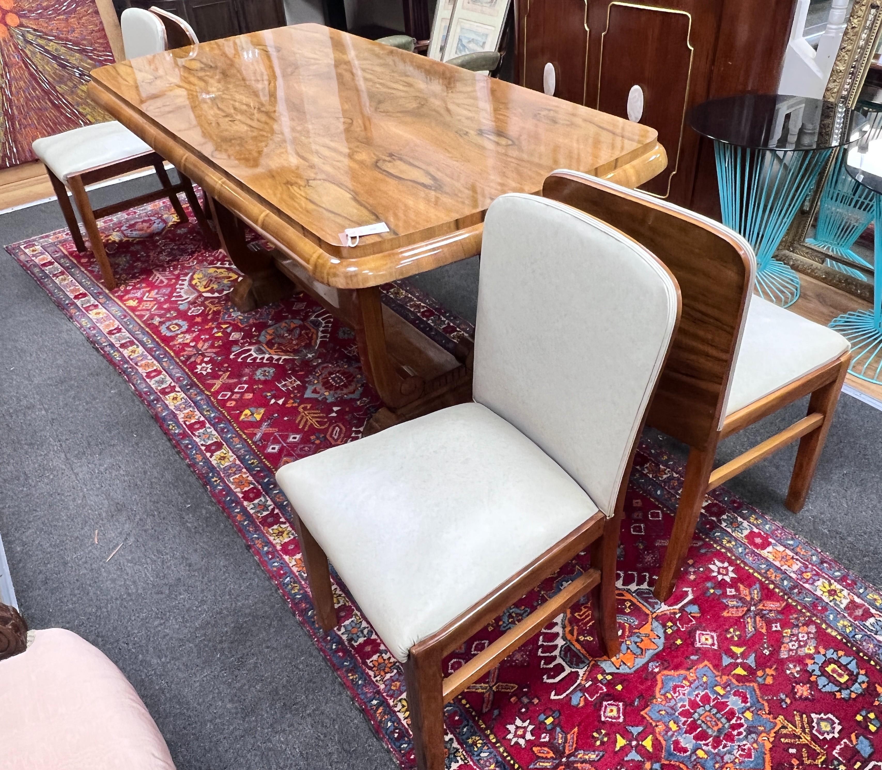 An Art Deco style walnut extending dining table, length 170cm extended, width 80cm, height 77cm and four chairs